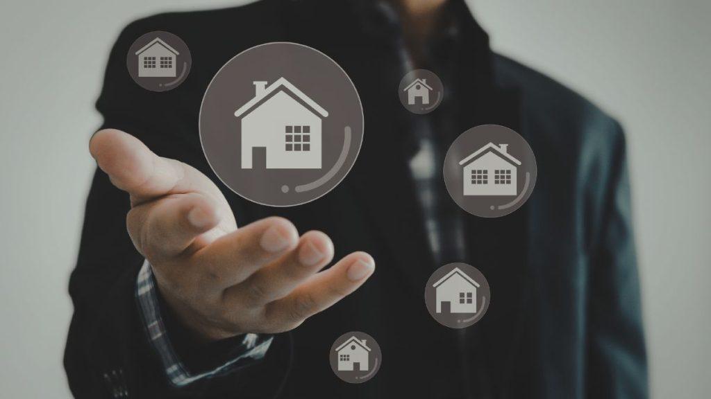 quantium-desarrollos-inversión-inmobiliaria-en-monterrey - VOZ Y OPINION Businessperson reaching toward floating house icons, symbolizing real estate services or property options.