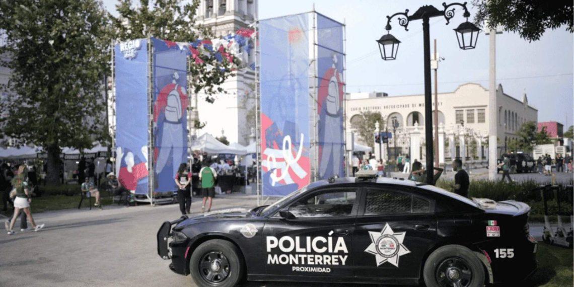 la-logistica-de-resguardo-para-selecciones - VOZ Y OPINION Police car labeled Policía Monterrey in the foreground at an outdoor street festival with blue banners, tents, and people in the background.